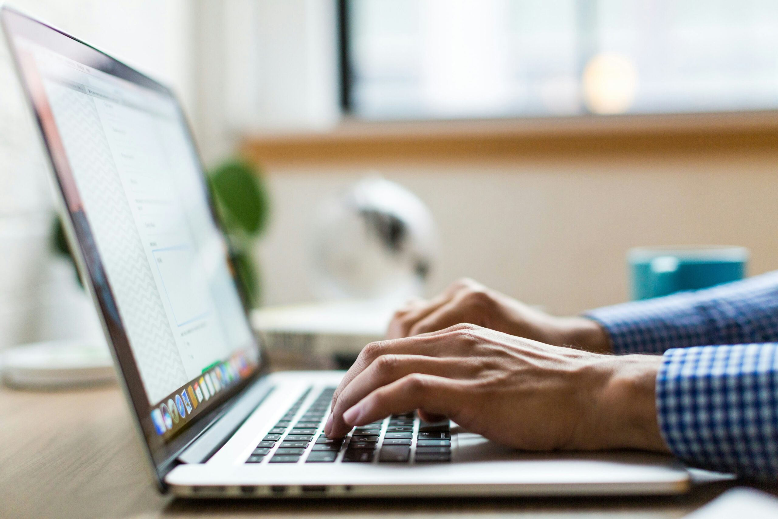 person typing on silver Macbook