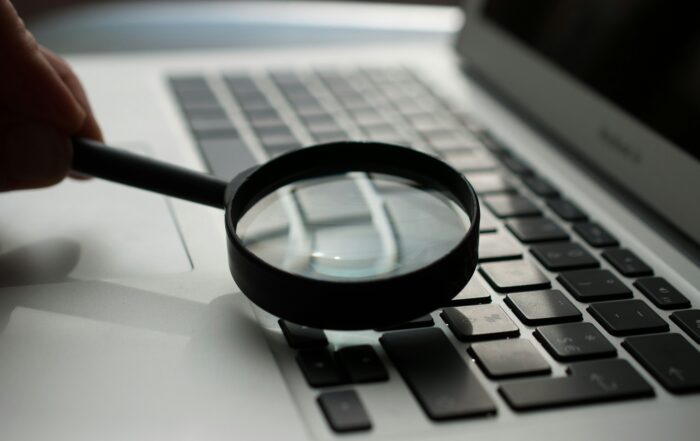 magnifying glass near gray laptop computer